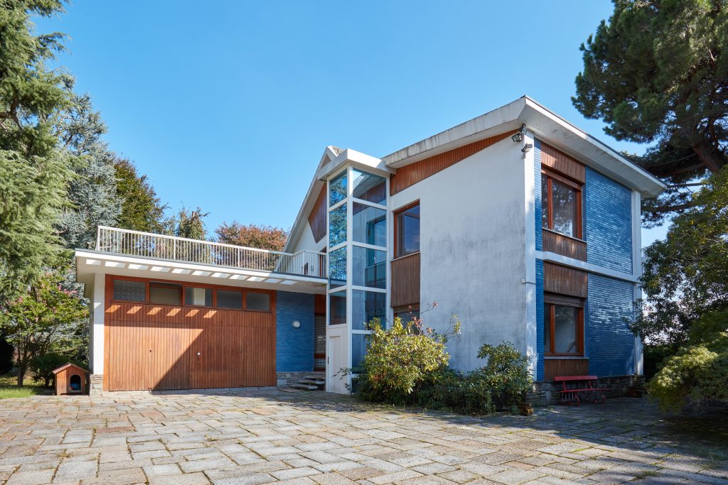 Old villa with garden in a sunny summer day, clear blue sky in I